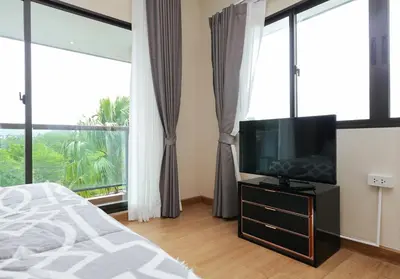 a bedroom with a bed and a flat screen tv at The Golden Palm Residence - Kathu - 10 min to Patong Beach in Kathu