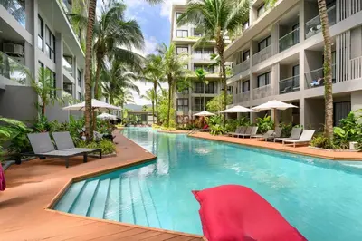 a swimming pool in a hotel with chairs and umbrellas at Diamond Condominium Phuket 2BR 5 min to Bangtao beach in Bang Tao Beach