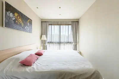 a bedroom with a large bed with two pink pillows at Diamond Condominium Phuket 2BR 5 min to Bangtao beach in Bang Tao Beach