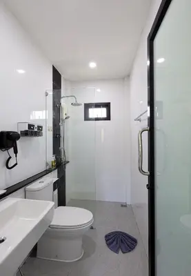 a bathroom with a toilet and a glass shower at RinFin Beach House - Bangtao in Ban Thalat Choeng Thale