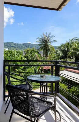 a table and chairs on a balcony with a view at RinFin Beach House - Bangtao in Ban Thalat Choeng Thale