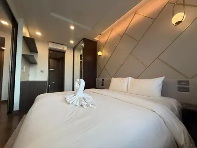 a bedroom with a large white bed with a swan on it at New 1BR Apartment in The Proud Karon Phuket in Karon Beach