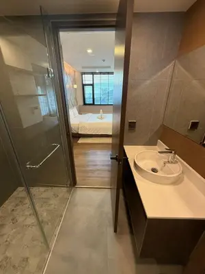 a bathroom with a sink and a shower and a bed at New 1BR Apartment in The Proud Karon Phuket in Karon Beach
