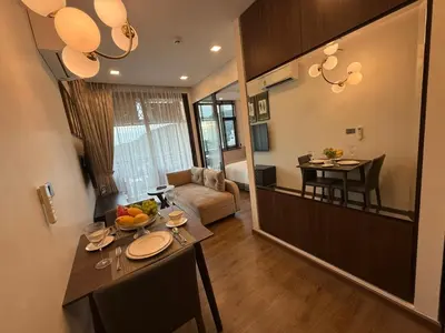 a kitchen and living room with a table in a room at New 1BR Apartment in The Proud Karon Phuket in Karon Beach