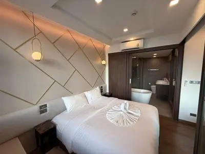 a bedroom with a white bed with a bowl on it at New 1BR Apartment in The Proud Karon Phuket in Karon Beach