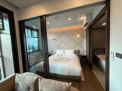 a bedroom with a bed and a tub in a room at New 1BR Apartment in The Proud Karon Phuket in Karon Beach