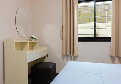 a bedroom with a bed and a mirror and a window at Haleema Signature Villa - Bangtao Beach in Ban Thalat Choeng Thale