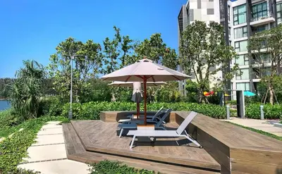 a patio with an umbrella and two chairs at Cassia 1 bedroom in Bang Tao Beach