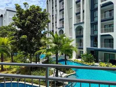 a view from the balcony of a hotel with a swimming pool at Modern 1 & 2 Bedroom Apartments Naiyang Phuket by Mango Family in Nai Yang Beach