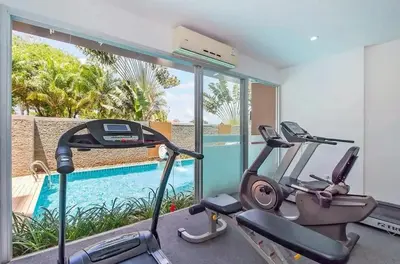 a gym with two exercise bikes and a swimming pool at Chic B309 in Karon Beach