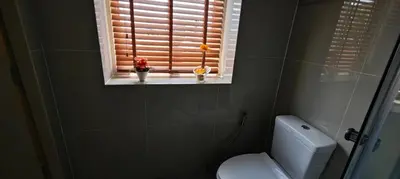 a bathroom with a window with a toilet and flowers at Palm Spring 301 in Patong Beach