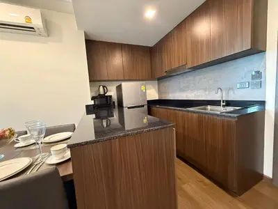 a kitchen with a counter with a sink and a refrigerator at Cozy 2BR Apartment in The Proud Karon Beach in Karon Beach