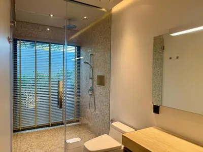 a bathroom with a shower and a toilet and a sink at Peaceful villa in the heart of the Anchan Tropicana project in Ban Phru Champa