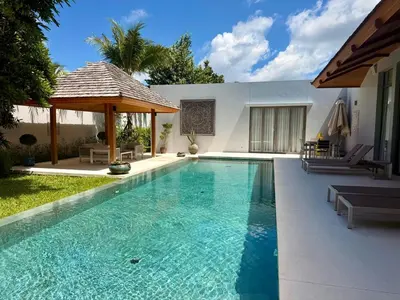 a swimming pool with a gazebo next to a house at Peaceful villa in the heart of the Anchan Tropicana project in Ban Phru Champa