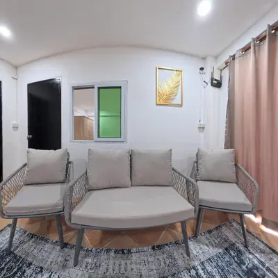 a living room with two chairs and a couch at Stay 94 Patong in Patong Beach
