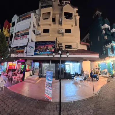 a building with tables and chairs in front of it at Stay 94 Patong in Patong Beach