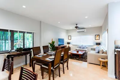 a dining room and living room with a table and chairs at Villa Vie Phuket Rawai 3 Bedrooms in Ban Saiyuan (1)
