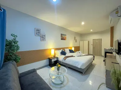 a hotel room with a bed and a couch at Ali House Patong in Patong Beach