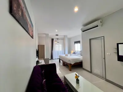 a living room with a couch and a bed at Ali House Patong in Patong Beach
