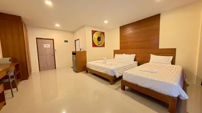 a hotel room with two beds and a kitchen at Baan Phu Chalong Place in Ban Suan