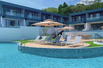 a swimming pool with chairs and umbrellas next to a building at Tierra Utopia
