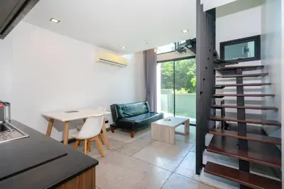a kitchen and dining room with a spiral staircase in a house at Stylish Loft at Utopia Nai Harn great amenities in Rawai Beach