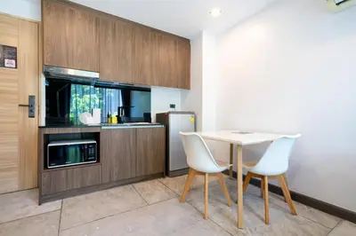 a kitchen with a table and chairs and a refrigerator at Stylish Loft at Utopia Nai Harn great amenities in Rawai Beach