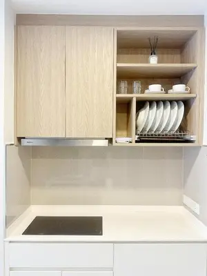 a kitchen with wooden cabinets and a stove top oven at Bangtao Rooftop Seaview Laguna Skypark Condominium in Bang Tao Beach