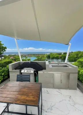 an outdoor patio with a table and a grill and a sink at Bangtao Rooftop Seaview Laguna Skypark Condominium in Bang Tao Beach