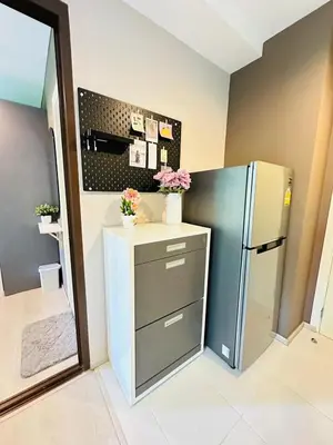 a kitchen with a refrigerator and a counter with flowers at Zcape garden view Phuket in Ban Rangeng