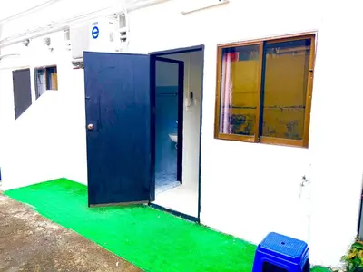 a building with a blue door and a green floor at Patong Canal Villa 109 in Patong Beach