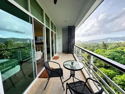 a balcony with a table and chairs on a building at Veloche Peaceful Condo In Karon Beach in Karon Beach