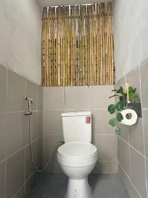 a bathroom with a toilet with a bamboo curtain at Beanstay hostel in Phuket Town