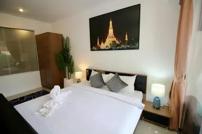 a bedroom with a white bed with a picture on the wall at Chic condominium A4 floor in Karon Beach