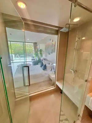 a bathroom with a glass shower and a bedroom at Veloche 2 Floor in Karon Beach
