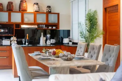 a table with a bowl of fruit on it in a kitchen at Rawayana 3 Bedroom Villa in Rawai Beach