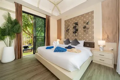 a bedroom with a large white bed and a large window at Rawai Park Big Garden Villa 3D10 in Rawai Beach