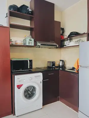 a kitchen with a washing machine and a microwave at Chic 10 minutes to reach the karon beach, with free swimming pool and gym, WIFI in Karon Beach