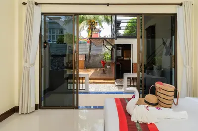 a house with a swan sitting on a bed in a room at JR Siam Inn Resort in Kata Beach