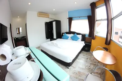 a bedroom with a bed and a table and chairs at Tulip Inn in Patong Beach
