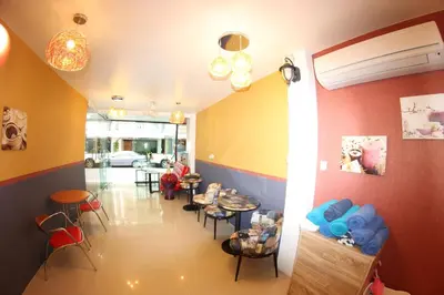 a waiting room with tables and chairs in a building at Tulip Inn in Patong Beach