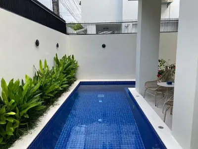 a swimming pool in the middle of a building with plants at Palazzo 126 Luxury 5BR Pool Villa in Patong in Patong Beach