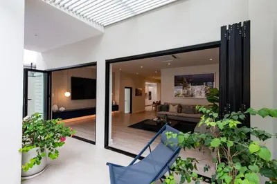 a living room with sliding glass doors and plants at Palazzo 126 Luxury 5BR Pool Villa in Patong in Patong Beach