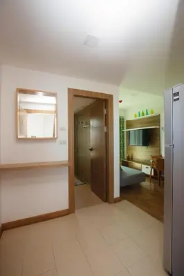 a living room with a refrigerator and a kitchen at Calypso Condo Naiharn in Phuket Town