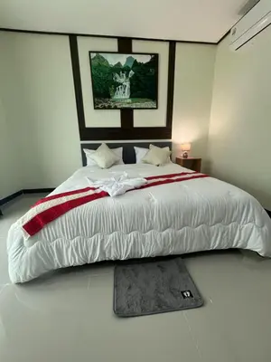 a bedroom with a large white bed in a room at 3P Phuket Airport Hotel in Phuket