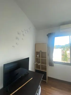 a living room with a table and a window at Town House in Ban Ket Ho