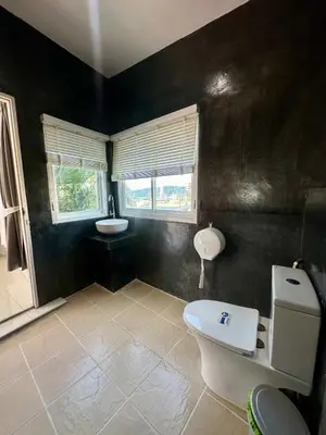 a black bathroom with a toilet and a sink at Amazing Seaview House 2 Bedroom Patong in Patong Beach