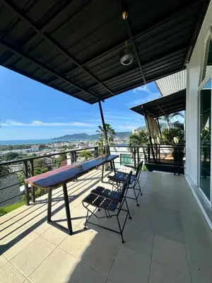 a patio with a table and chairs on a balcony at Amazing Seaview House 2 Bedroom Patong in Patong Beach