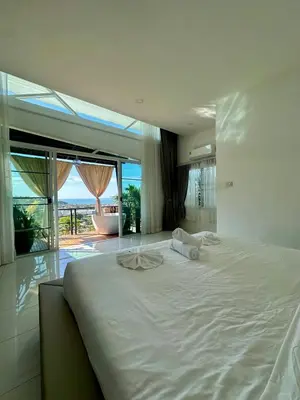 a bedroom with a large white bed with a view at Amazing Seaview House 2 Bedroom Patong in Patong Beach