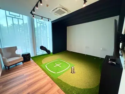 a room with a green carpet with a baseball field at The Legendary Bang Tao 2-bedrooms apart #402 in Bang Tao Beach